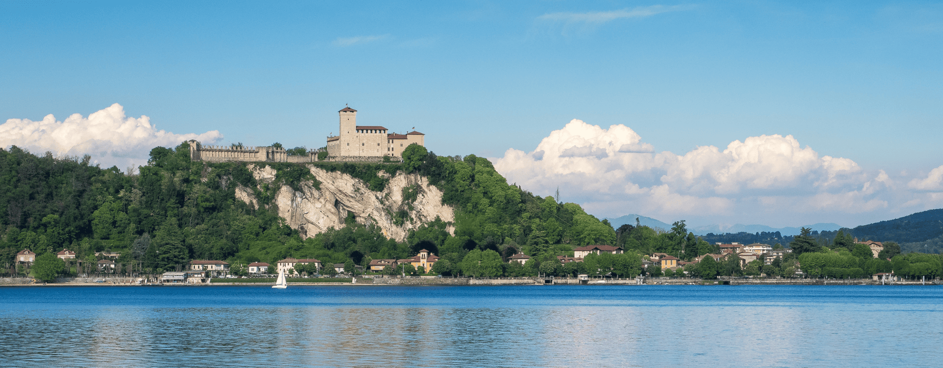 Borgo vicino a Milano affacciato sul lago con montagne sullo sfondo